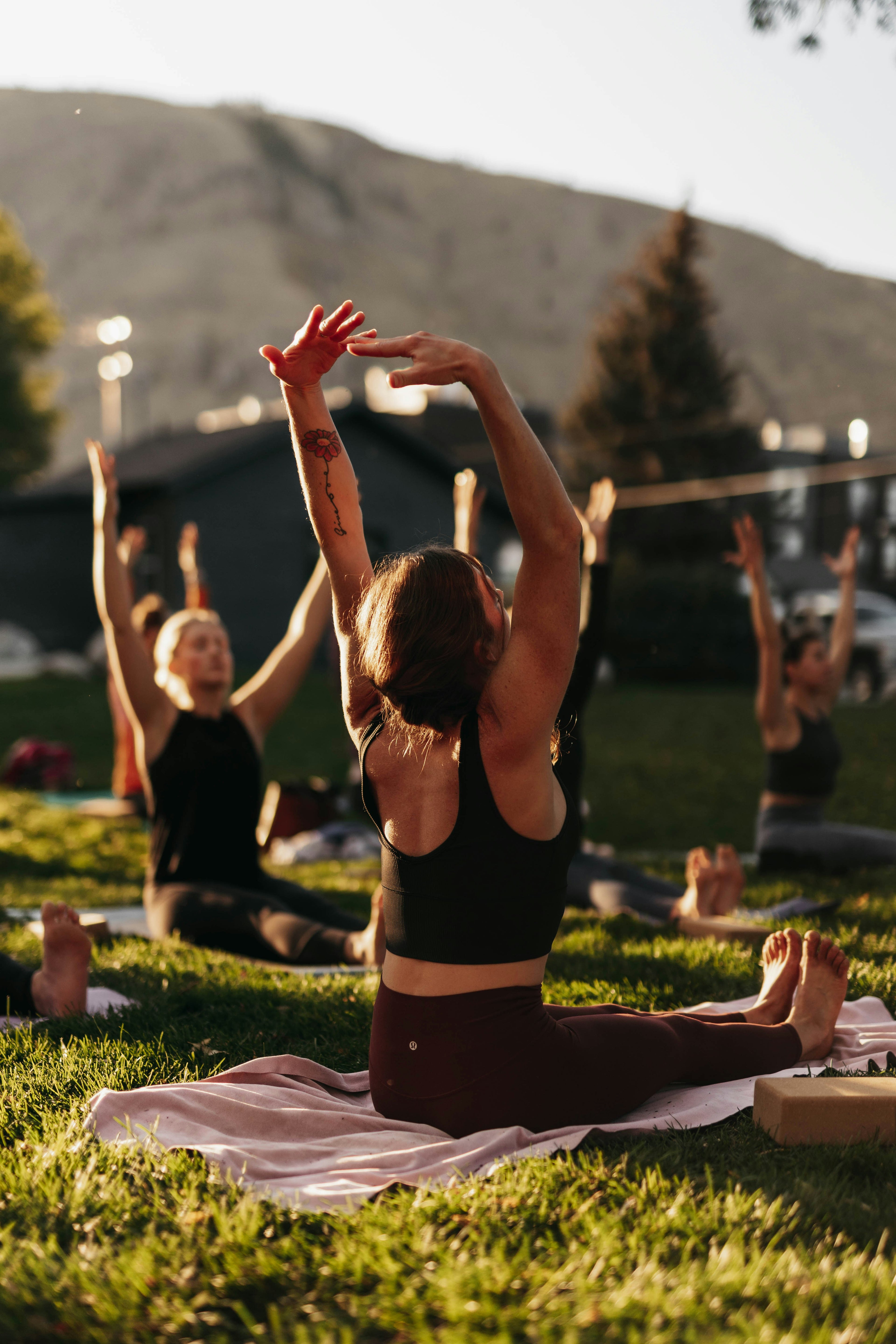 Woman reaching skyward at golden hour in MOCA activewear